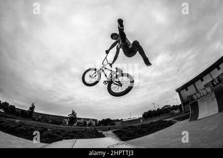 Cyclist stunt riding, often referred to as stunting, is a bicycle sport characterized by stunts involving acrobatic maneuvering of the sports bicycle and sometimes the rider. Common maneuvers in stunt riding include wheelies, stoppies, and burnouts. France. Stock Photo