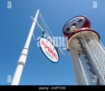 Vintage Imperial Gas Pump: An Imperial sign with an old gas pump behind against a bright blue sky. Stock Photo