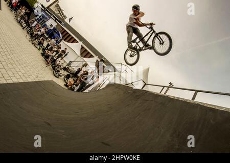 Cyclist stunt riding, often referred to as stunting, is a bicycle sport characterized by stunts involving acrobatic maneuvering of the sports bicycle and sometimes the rider. Common maneuvers in stunt riding include wheelies, stoppies, and burnouts. France. Stock Photo