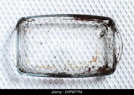 Dirty baking dish with a thick layer of carbon. Glassware for baking with soot, carbon deposits, old dried fat. Stock Photo