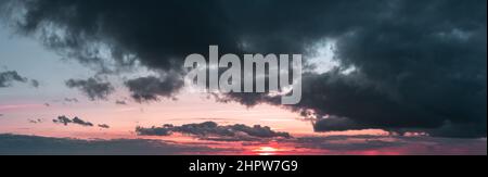Sunset panorama with dark clouds and red sky Stock Photo