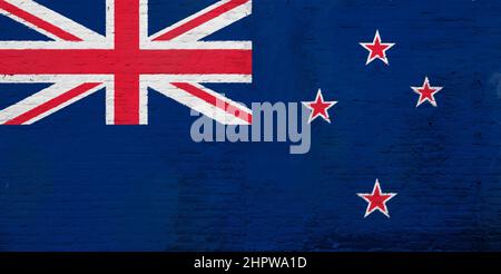Full frame photo of a weathered flag of New Zealand painted on a plastered brick wall. Stock Photo
