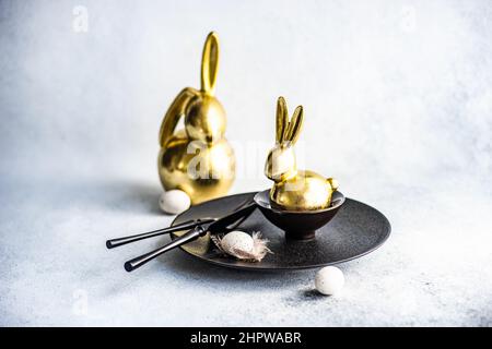 Festive table setting for Easter dinner on concrete background with black cutlery Stock Photo