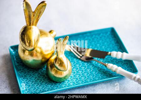 Place setting for festive Easter dinner using with golden bunnies Stock Photo