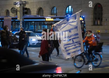 Munich, Germany. 23rd Feb, 2022. Participant with flag 'Freedom'. On February 23, 2022, hundreds of anti-vaxxers gathered to demonstrate against mandatory vaccination and covid protection measures. They lined up between the Geschwister-Scholl-Platz and Odeonsplatz to form a chain of lights. The mask obligation and distance rules were hardly kept. (Photo by Alexander Pohl/Sipa USA) Credit: Sipa USA/Alamy Live News Stock Photo