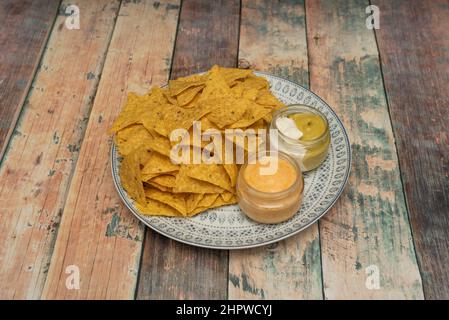 Nachos are a dish of Mexican origin, which consist of frying pieces of corn tortilla covered with a special cheese called 'queso para nachos' Stock Photo