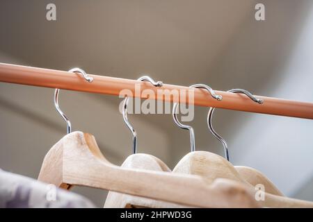 Wooden hangers hanging on a light brown bar or tile Stock Photo