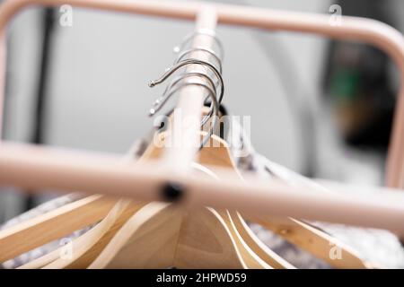 Wooden hangers hanging from a bar of a donkey with various items of clothing Stock Photo