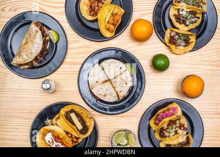 Set of dishes of typical Mexican recipes with tacos pastor, cochinita pibil, fresh fruits and salt Stock Photo