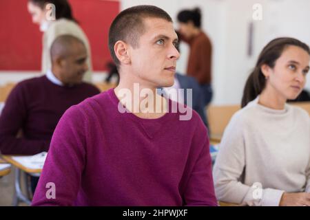 European man with other adult students in studying with colleagues Stock Photo