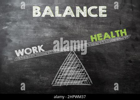 the words work outweighs the word health on a swing drawing with chalk on a blackboard. Concept photo of the ability to keep a balance between work Stock Photo