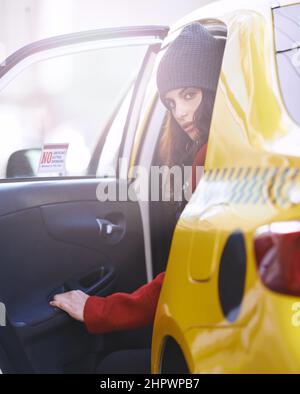 On the move in the city. Portrait of a fashionable young woman getting into a cab in the city. Stock Photo