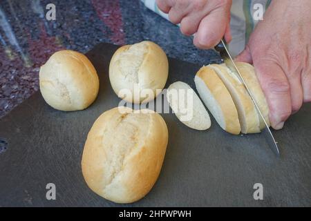 Swabian cuisine, preparation French Toast, cut up stale bread rolls, bread knife, cutting board, dessert, dessert, men's hands, Germany Stock Photo