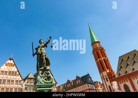 Justitia - Lady Justice - sculpture on the Roemerberg square in Frankfurt, built 1887 with roof of church Stock Photo