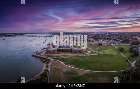 Stunning aerial sunset shot of St Augustine Florida, Castillo de San Marcos with four cannon bastions purple, blue, red sky Stock Photo