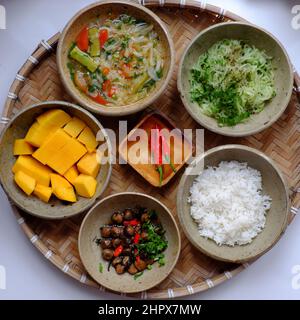 Vietnamese vegan daily family meal for lunch, tray of rice dish with fried chayote, sour soup, straw mushrooms cook with sauce, vegetarian meal Stock Photo