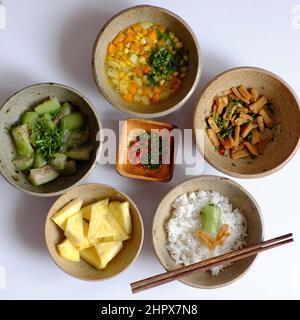 Top view Vietnamese daily meal for lunch time, tray of rice dish with melon, soup bowl from carrot, corn, potato, tofu skin fried, pineapple, sauce, v Stock Photo