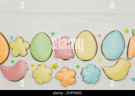 Easter cookies on wooden table. Colorful eggs, flowers and a rabbit. Stock Photo