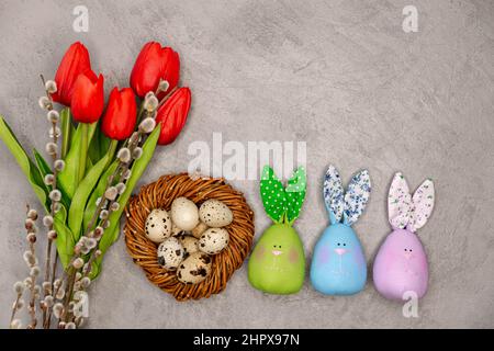 Easter decoration on the grey background. Flowers, eggs in the nest Stock Photo