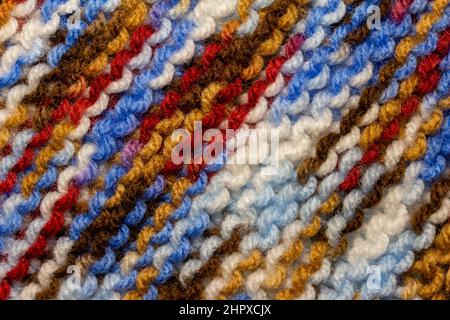 Full frame abstract texture background of hand knitted yarn in a simple garter stitch, with a bright multi-colored pattern Stock Photo