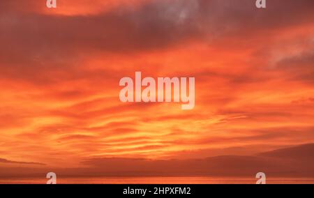 Orange sunrise, sunset over the sea in strong fiery colors. Sky replacement. Stock Photo