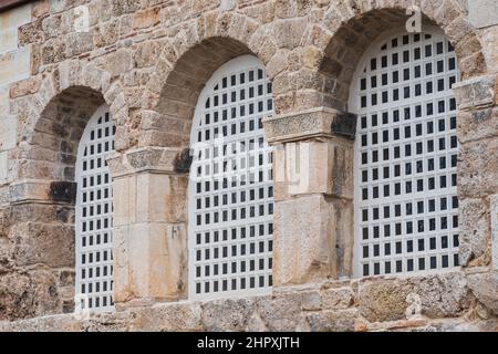 close-up white wrought iron bars in an arch-shaped window in an old house Stock Photo