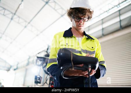 engineer checking control panel and teaching new Automatics robot arm and operating control machine in factory. Stock Photo