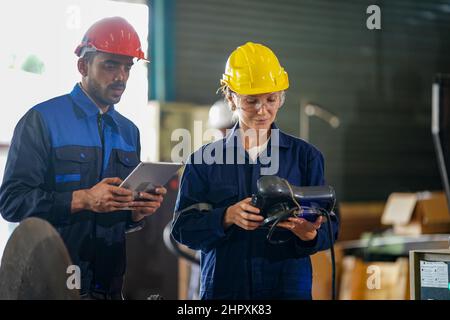 engineer checking control panel and teaching new Automatics robot arm and operating control machine in factory. Stock Photo