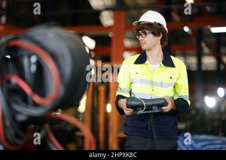 engineer checking control panel and teaching new Automatics robot arm and operating control machine in factory. Stock Photo