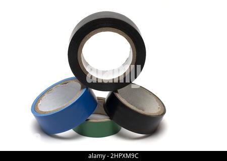 Close up of four different colored stacked rolls of black blue and green electrician insulating tape on white background Stock Photo