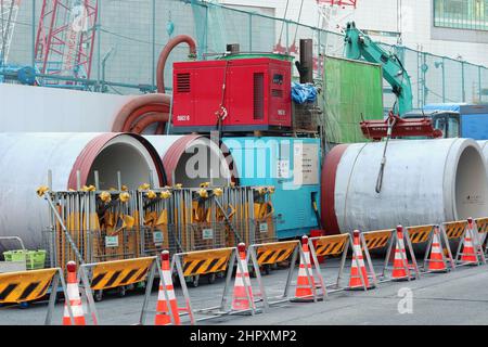 Materials and machinery, including sludge removal equipment, by a large construction site in central Tokyo's Nihonbashi area. Stock Photo