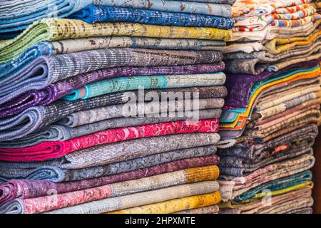 Large rows of pieces of fabric made of cotton, polyester, and other materials in different colors and prints of clothing, soft focus Stock Photo