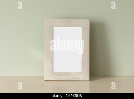 empty frame on table on green wall background Stock Photo