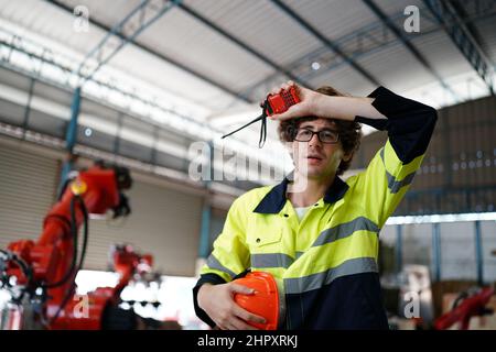 engineer checking control panel and teaching new Automatics robot arm and operating control machine in factory. Stock Photo