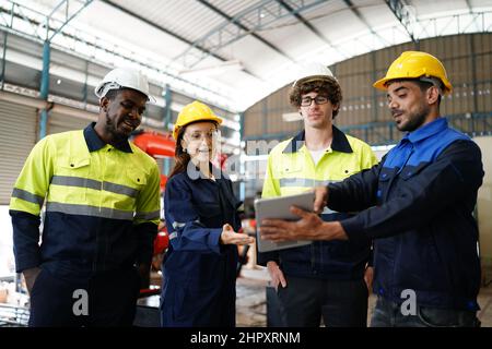 engineer checking control panel and teaching new Automatics robot arm and operating control machine in factory. Stock Photo