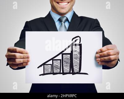 The numbers are in. Cropped shot of a businessman holding up a hand-drawn profit graph. Stock Photo