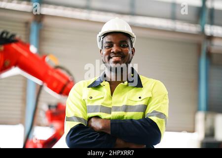 engineer checking control panel and teaching new Automatics robot arm and operating control machine in factory. Stock Photo