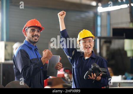 engineer checking control panel and teaching new Automatics robot arm and operating control machine in factory. Stock Photo