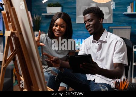Design students analyzing vase sketch on tablet computer drawing illustration on canvas using graphic pencil. Young artists studying for art lesson sketching paint masterpiece. Concept of painting Stock Photo