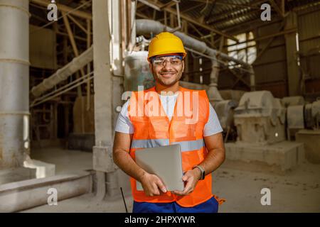 Smiling young construction engineer working in plant Stock Photo