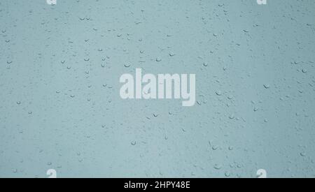 Rain drops on a window and overcast sky. Abstract view of rain drops on a window Stock Photo