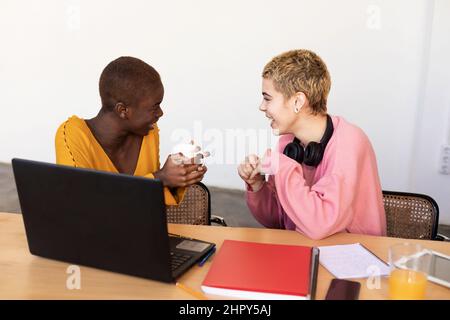 Multiethnic female couple relaxing at home while having breakfast Stock Photo