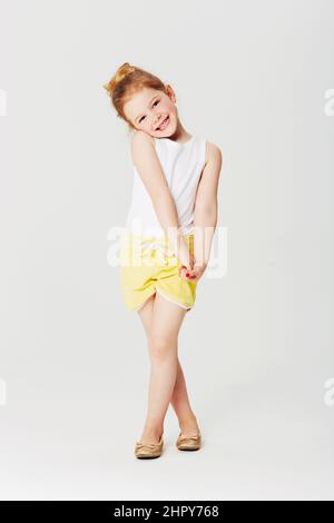 Please, pretty please...... Full length studio portrait of an adorable little girl in a sweet pose. Stock Photo