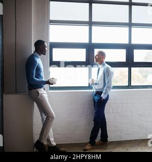 Id like us to explore some of your ideas further. Shot of two businessmen having a discussion in an office. Stock Photo