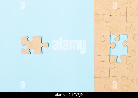 The correct missing puzzle piece on a light blue background in a top view Stock Photo