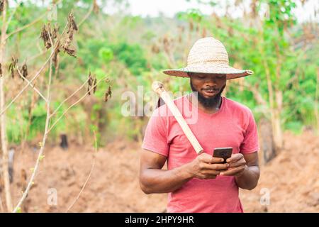 African male farmer checking his phone Stock Photo