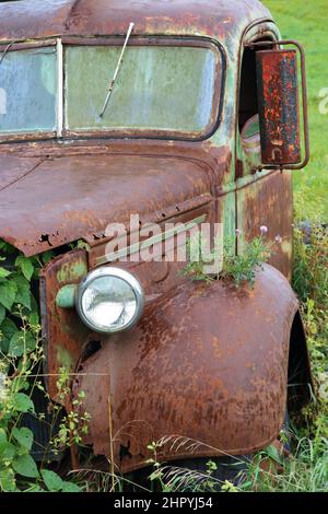 Front view of an old rusty vintage abandoned antique truck in the field Stock Photo