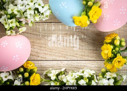 Frame of decorated easter eggs and flowers with rustic wooden background for copy space Stock Photo