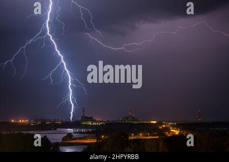 Thunderstorm above power plant with gorgeous lightning at night Stock Photo