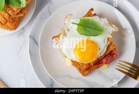 Sandwich with a fried egg, bacon, cheese and spinach Stock Photo